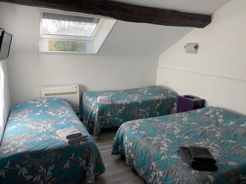 Cette petite chambre comprend 2 lits et une fenêtre. dans l'établissement hôtel Le Cosy, à Pont-de-Chéruy