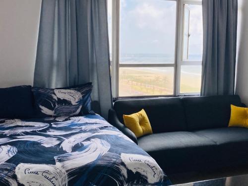 - un lit et un canapé dans une chambre avec fenêtre dans l'établissement 605 Tenbury Beach Apartment, à Durban
