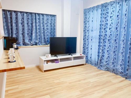 a living room with a tv and blue curtains at 浅草圈4层独栋别墅 免费停车场 近车站 可直达机场 in Tokyo