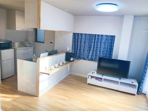 a living room with a tv and a kitchen at 浅草圈4层独栋别墅 免费停车场 近车站 可直达机场 in Tokyo