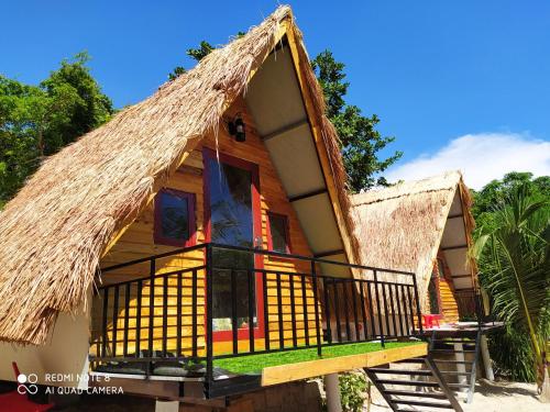 a house with a thatched roof and a balcony at The Sunrise Anh Tu in Cam Ranh
