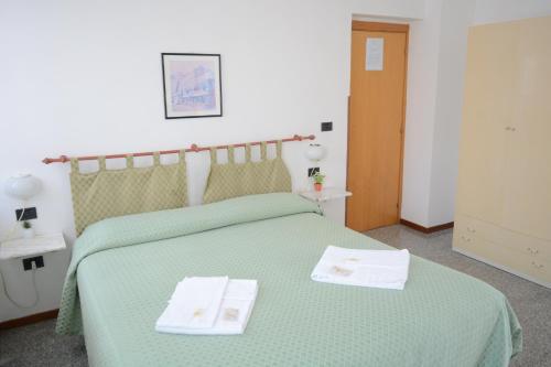 a bedroom with a green bed with two towels on it at Cantina Dell'Arte in Ascoli Piceno