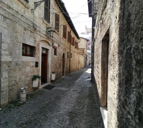 an alley in an old town with stone buildings at Cantina Dell'Arte in Ascoli Piceno