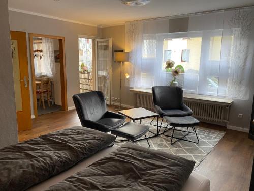 een slaapkamer met 2 stoelen, een bed en een raam bij Forsternest in Hameln