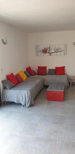 Zimmer mit 2 Betten mit roten und gelben Kissen in der Unterkunft Soluna in Cargèse