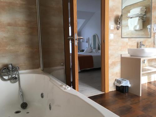 y baño con bañera y lavamanos. en Hotel Valle de Cabezón, en Cabezón de la Sal