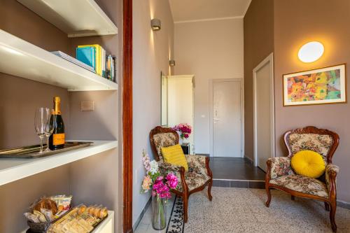 a hallway with two chairs and a table with flowers at Marlin Rooms in Cagliari