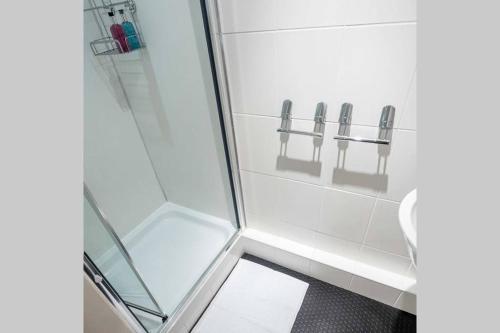 La salle de bains est pourvue d'une douche avec une porte en verre. dans l'établissement ☆ Central, Spacious Apartment Close to University☆, à Dundee