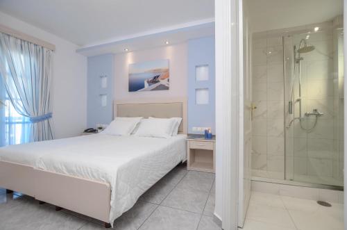 um quarto branco com uma cama e um chuveiro em Ilion Hotel em Naxos Chora