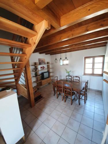 comedor con mesa y techos de madera en Gîte Le Bonnet, en Marlieux