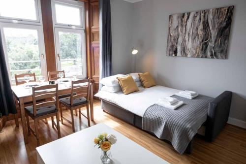 a bedroom with a bed and a dining room with a table at ☆ Bright, Modern West-End Apartment ☆ in Dundee