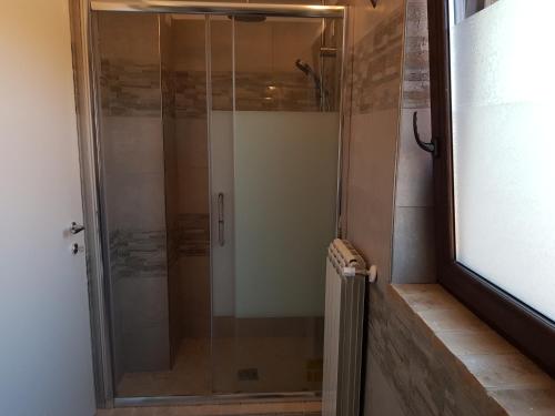 een douche met een glazen deur in de badkamer bij La Culla del Conte in Bucchianico