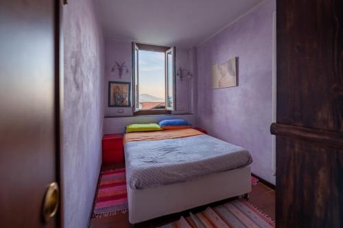 una piccola camera con letto e finestra di Appartamento VillaGiò - Terrazzo a Stresa