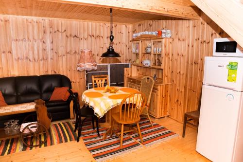 a kitchen and dining room with a table and a refrigerator at Mere kodumajutus in Kärdla