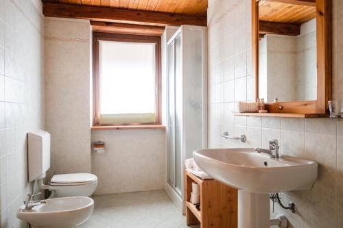 ウルクスにあるResidence Cascina Genzianellaのバスルーム(洗面台、トイレ付)、窓が備わります。