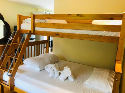 two bunk beds in a room with white sheets at Baan Sang Singh in Chiang Mai