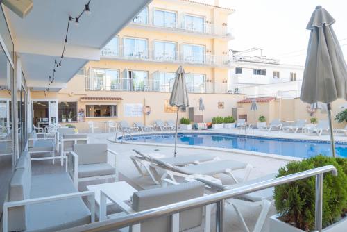 a hotel with a swimming pool with chairs and umbrellas at Hotel S'Agoita in Platja d'Aro