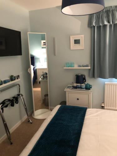 a bedroom with a bed and a mirror and a television at Dana Villa Holiday Accommodation in Oban