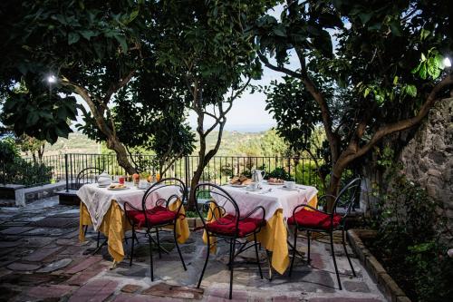 a table with red chairs and white table cloth at Hotel Villa Gli Asfodeli in Tresnuraghes