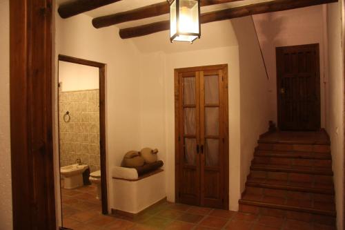 a hallway with a bathroom with a toilet and a staircase at Casas de Cantoblanco in Viñuela