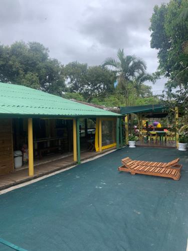 a building with a green awning next to a patio at Hostel Encantadas Ecologic in Ilha do Mel