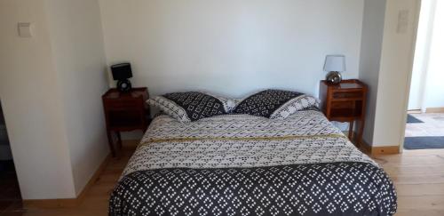 a bed in a bedroom with two night stands and two tables at au fabuleux festin in La Possonnière