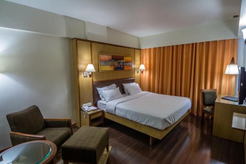 a hotel room with a bed and a bathroom at The President-A Boutique Hotel in Ahmedabad