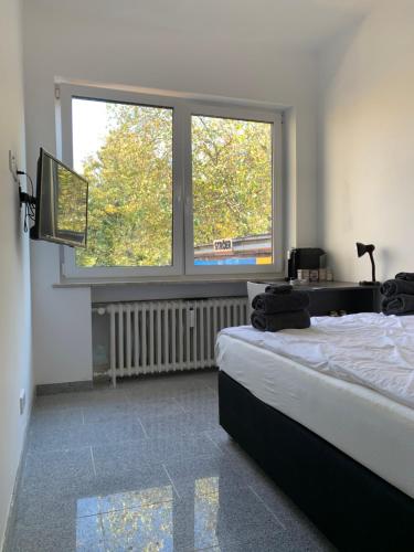 Un dormitorio con una cama y una ventana grande. en Geroweiher Doppelbettzimmer Mönchengladbach-Stadtmitte, en Mönchengladbach