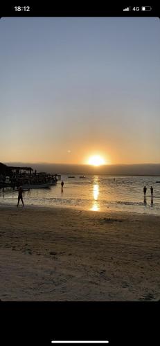a group of people playing on the beach at sunset at Hostel Encantadas Ecologic in Ilha do Mel
