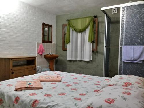 um quarto com uma cama, um chuveiro e uma janela em Recanto dos Pioneiros em Nova Petrópolis