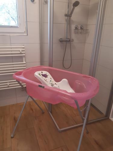 y baño con ducha y bañera rosa. en Ubytování U Křivánků, en Telč