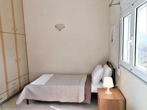 a small bedroom with a bed and a window at Villa Aeolus with private overflow, endless, heated pool in Prinés