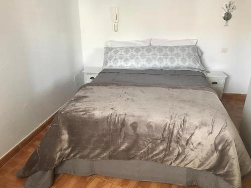 ein Bett mit einer Decke darauf in einem Schlafzimmer in der Unterkunft Palmera 16 in Santa Lucía