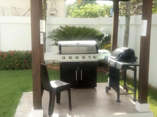 a grill and a chair sitting next to a table at Luxury in the Caribbean in Sosúa
