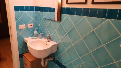 a bathroom with a sink and a blue tiled wall at Glicine & more Forlì in Forlì