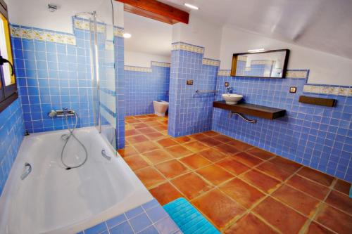 a blue tiled bathroom with a tub and a toilet at Finca Argudo - private pool villa in Moraira in Moraira