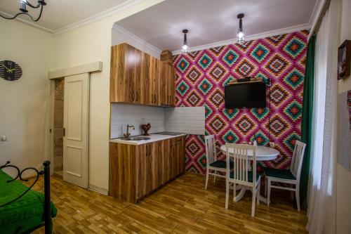 eine Küche mit einem Tisch und einem TV an der Wand in der Unterkunft downtown apartment near Sulfur baths in Tbilisi City