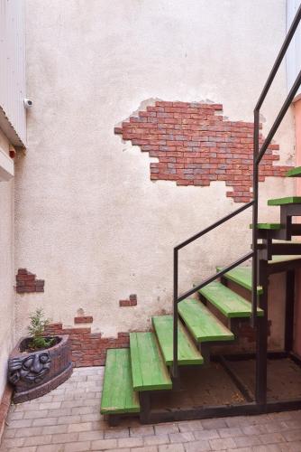 a brick wall with green stairs next to a brick building at New Historical Museum Apartment in Kharkiv