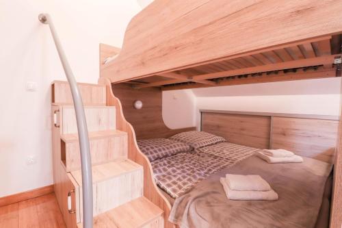 a small bedroom with a bunk bed and stairs at Timber Apartment in Bohinj