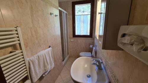 a bathroom with a sink and a toilet and a window at Saturnia Tuscany Country House in Saturnia