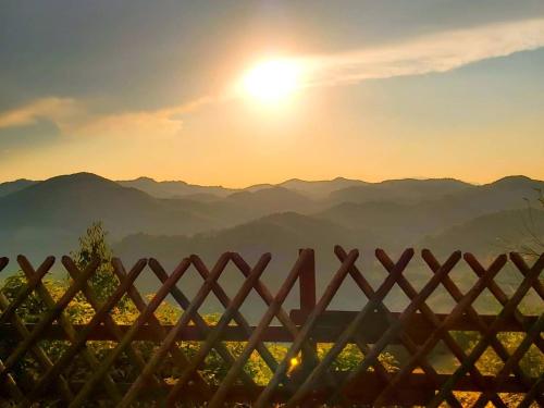 a view of the mountains through a fence at sunset at Country House Il Biroccio in Urbino