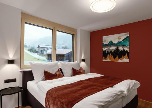 a bedroom with a large bed with a large window at Verwall Apartment Arlberg - mit Sauna in Wald am Arlberg