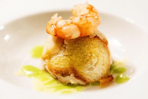 a white plate with a piece of food with shrimp on it at Relais Briuccia e Ristorante Capitolo Primo in Montallegro
