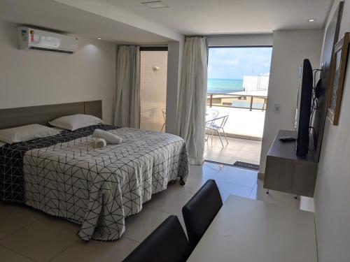 Schlafzimmer mit einem Bett und Meerblick in der Unterkunft Gold Flat - Praia do Cabo Branco in João Pessoa