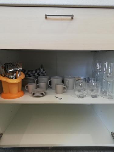 a shelf with cups and plates and glasses on it at A cà ed Franca e Giaco in La Morra