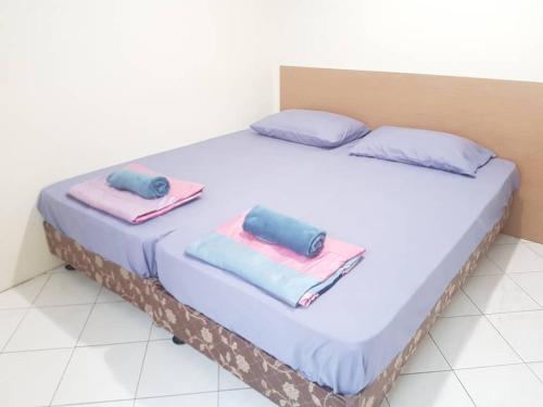 a bed with two towels on top of it at Pangkor Coral Bay Resort(2 bedrooms) in Pangkor