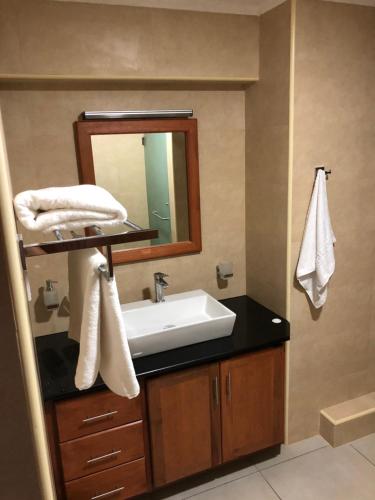a bathroom with a sink and a mirror at Kolibri Holiday Apartments in Victoria