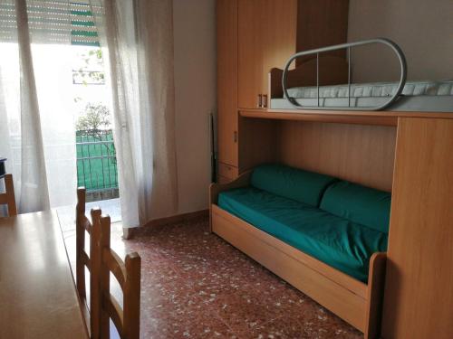 1 dormitorio con cama verde y espejo en Casa delle bambole, en Scauri