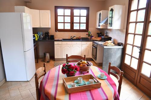 une cuisine avec une table avec un bol de fruits dessus dans l'établissement Maison de campagne sud-ouest CARBONNE en OCCITANIE, à Carbonne