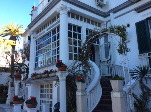 a white house with potted plants on the stairs at Albergo Santa Teresa in Torre del Greco